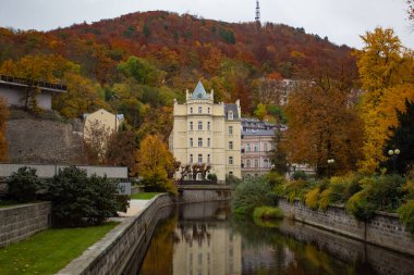 Çek Cumhuriyeti 'nin Karlovy Vary kentindeki sonbahar ormanının arka planına karşı Ohre Nehri yakınlarındaki Beyaz Kale manzarası. Yüksek kalite fotoğraf