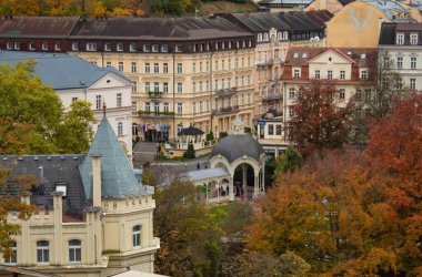 Çek Cumhuriyeti 'nin Karlovy Vary kentinde sonbaharda, sonbahar ağaçlarının arka planında terapötik termal yaylarla sütunların görüntüsü. Yüksek kalite fotoğraf