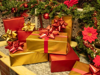 Noel ağacının arka planında kırmızı topları ve Noel çiçekleri olan hediyelerle dolu bir Noel köşesi. Yüksek kalite fotoğraf