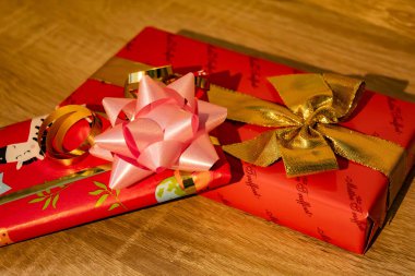 Altın kurdeleler ve pembe kurdelelerle paketlenmiş kırmızı hediyelerle yılbaşı hediyeleri. Yüksek kalite fotoğraf
