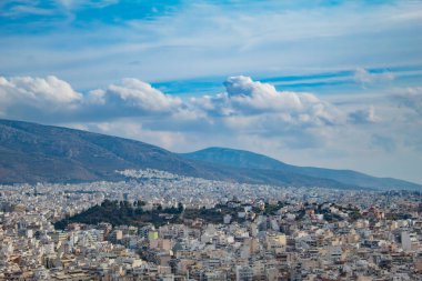 Pofuduk bulutlar, mavi gökyüzüne uzanan dağlar, Yunanistan 'ın Atina kentinin manzarası. Yüksek kalite fotoğraf