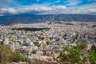 Yunanistan 'ın arka planında yemyeşil dağlar ve mavi gökyüzü bulunan kuş bakışı manzaralı dev Atina kenti. Yüksek kalite fotoğraf