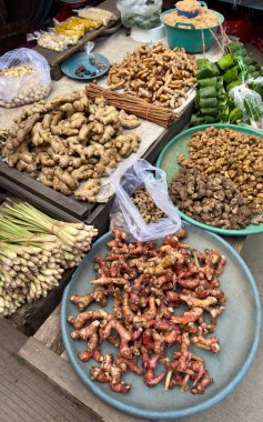 Bir sokak satıcılarının tezgahında zencefil, limon otu ve tanımlanamayan kahverengi ve kırmızı bileşenler de dahil olmak üzere kurutulmuş otlar, kökler ve baharatlar sergileniyor..