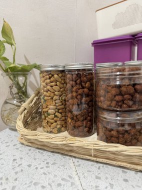 Lezzetli, çeşitli fındıklar ve cam kavanozlardaki aperatifler örgü tepside dizilmiş mükemmel bir gurme yemeği hala hayatta.