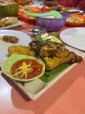 Endonezya usulü canlı sambal çeşnili ızgara tavuk. Aromatik baharatlar ve taze malzemeler cezbedici bir aşçılık deneyimi yaratır. Yemek blogları için mükemmel..