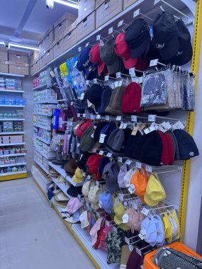 Perakende Raflarında Gösterilen Renkli Şapkalar ve Başlıklar: Çeşitli türde başlık koleksiyonu sergilenen canlı bir perakende sahnesi.