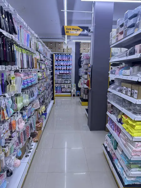 Parlak perakende mağazası koridorunda renkli ev eşyaları ve güzellik ürünleri raflarda düzgünce sergileniyor