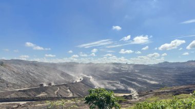 Açık kömür madeni arazisi endüstriyel işlemleri olan açık mavi bir gökyüzü altında