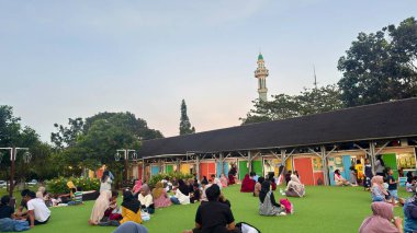 İnsanlar hareketli ve huzurlu bir camide namaz kılmak için dışarıda toplanıyor.