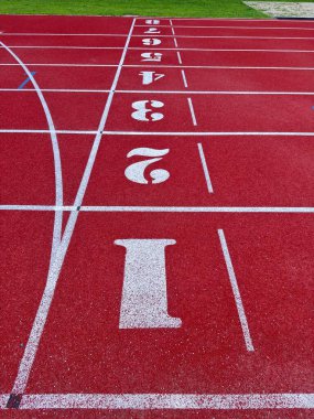 Bir spor müsabakasında koşucuların yarışması için kulvar numaralarıyla atletik yarış pisti