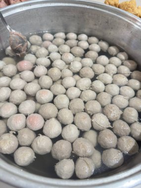 Freshly cooked meatball ingredients ready for delicious Asian street food recipes in a stainless steel pot bubbling with flavor