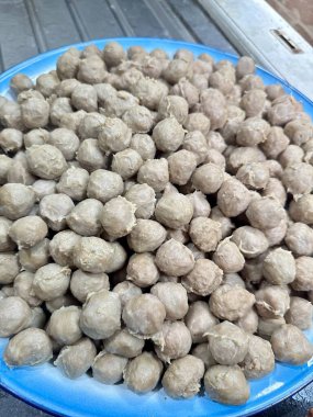 Ev yapımı köfteler canlı mavi bir tabakta üst üste yığılmış lezzetli bir aile yemeği ya da yemek servisi için hazır, konfor ve yemek zevki sunuyor.