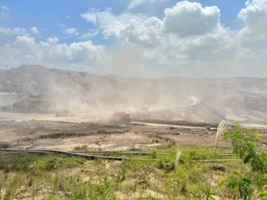 Çevreyi ve gökyüzünü kirleten toz kirliliğiyle çarpıcı bir açık maden sahası, çevresel etkileri ve endüstriyel faaliyetleri gösteriyor