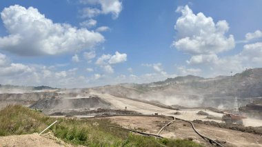 Açık maden işletmelerinin dinamik hava görüntüsü açık mavi gökyüzü altında toprağı kazmak, sanayi ve kaynak çıkarma