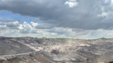 Dinamik gökyüzü ile dramatik açık maden kömürü arazisi enerji, kaynak ve çevresel etki projeleri için güçlü görseller sunar