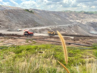 Heavy machinery working at a large quarry with piles of rock for industrial construction projects and resource management solutions