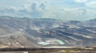 Geniş bir açık kömür madeninin dramatik hava görüntüsü çevresel etkiyi ve kaynakların ıssız ve güçlü bir arazide çıkarılmasını gösteriyor.
