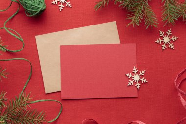 Noel kırmızı tebrik kartı, çevre dostu xmalar, kırmızı tekstil arka planında yeni yıl süslemeleri, ekolojik Noel tatili konsepti, eko dekor afişi.