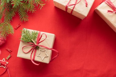 Noel ve sıfır atık, kırmızı tekstil arka planında el işi kağıdında çevre dostu doğal ambalaj kutuları, ekolojik Noel tatili konsepti, fotokopi alanı olan ekolojik dekor afişi