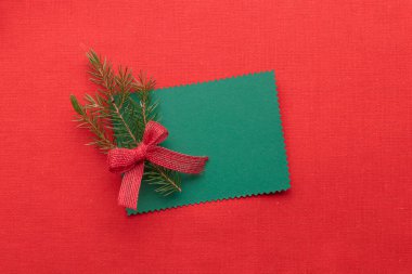 Noel yeşil tebrik kartı, çevre dostu xmalar, kırmızı tekstil arka planında yeni yıl süslemeleri, ekolojik Noel tatili konsepti, eko dekor afişi.