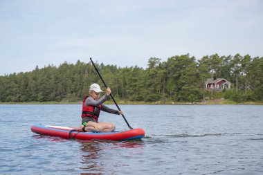 Baltık Denizi 'nde sörf tahtasında, Finlandiya Körfezi' nde, çocuk tatili, Finlandiya 'da aktif yaz tatili.