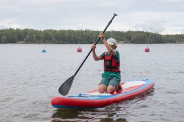 Baltık Denizi 'nde sörf tahtasında, Finlandiya Körfezi' nde, çocuk tatili, Finlandiya 'da aktif yaz tatili.