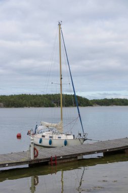 Adanın limanındaki yelkenli gemi Finlandiya 'da, Baltık Denizi' nde bir şamandıraya bağlı, Baltık Denizi 'nde deniz kenarında geleneksel yelken yatı, takımadalarda yaz tatili.