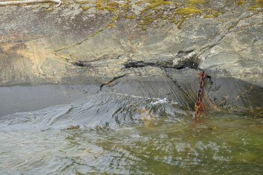 Dalgaların ve Baltık deniz marinasının sularındaki paslı demirleme zincirinin yakınına. Finlandiya 'da yaz.