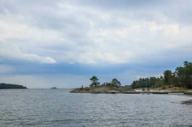 Baltık Denizi 'ne bakan boş sandalyelerle Kuzey yaz manzarası dinleniyor. Finlandiya 'da güzel bir deniz ve gökyüzü geçmişi olan yaz tatili. Finlandiya Körfezi Bayrağı
