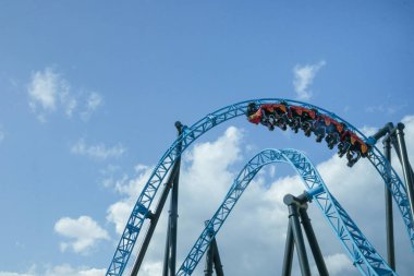 Helsinki, Finlandiya - 19 AUGust 2024: Linnanmaki lunaparkı hareket halindeki hız treni Taiga, arka planda mavi gökyüzü, mutlu insanlar