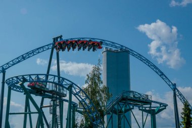 Helsinki, Finlandiya - 19 AUGust 2024: Linnanmaki lunaparkı hareket halindeki hız treni Taiga, arka planda mavi gökyüzü, mutlu insanlar