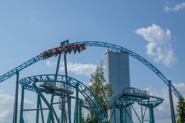 Helsinki, Finlandiya - 19 AUGust 2024: Linnanmaki lunaparkı hareket halindeki hız treni Taiga, arka planda mavi gökyüzü, mutlu insanlar