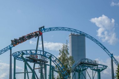 Helsinki, Finlandiya - 19 AUGust 2024: Linnanmaki lunaparkı hareket halindeki hız treni Taiga, arka planda mavi gökyüzü, mutlu insanlar