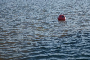 Küçük dalgalı bir denizde plastik kırmızı şamandıra, Finlandiya, marina