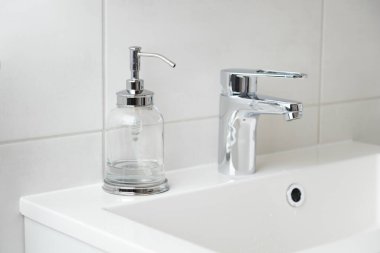 El yıkama ve hijyen konsepti. Cam makinesinde sıvı dezenfektan sabun ve banyoda musluk suyu, kapat. Kişisel hijyen, sağlık hizmetleri ve koronavirüs önleme