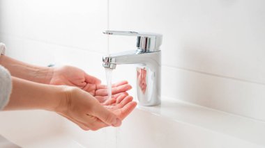 Doğal kaynaklar afişinin sürdürülebilir kullanımı. Kadın musluktan su kullanıyor. Krom musluktan su akıyor. Su kaynakları kavramını, çevre koruma kavramını kullanarak