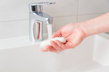 Lavaboda akan su, cilt bakımı konsepti, beyaz minimalist banyo.