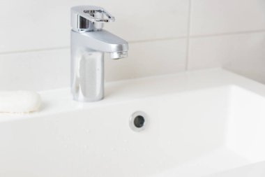 Modern banyo krom musluğu, beyaz fayans duvarı, su musluğu ve lavabo sabun, temizlik konsepti, kapalı su, doğal başvuru kavramlarını kopyalama alanı ile kaydet