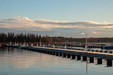 Sonbaharda deniz marinası, sakin bir denizde terk edilmiş yelkenliler, limanda boş iskele, sonbahar, Finlandiya 'da kısa yelken mevsimi, Suomenoja