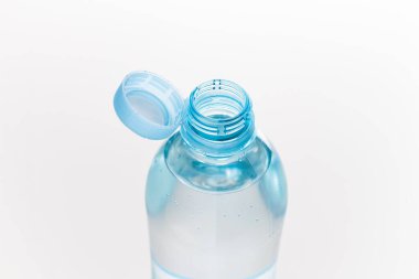 Gri arka planda izole edilmiş plastik bir şişeye yeni bir kapak iliştirilmiş. Çevre koruma kavramı