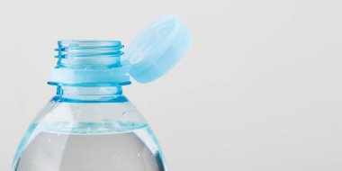 Beyaz arka planda durağan plastik kapaklı bir şişe. Yeni tasarım, kapağın açıldıktan sonra şişeye bağlı kalması ve tüm paketin toplanıp geri dönüşümünün kolaylaştırılması anlamına geliyor. Yüksek kaliteli fotoğraf.