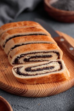 Ev yapımı haşhaş tohumu, dilimlenmiş bejgli, geleneksel Macar, Doğu Avrupa Noel 'i ve tahta kesim tahtasındaki Paskalya tatlı ekmeği. Masaya yakın çekim yap. Dikey kenar görünümü