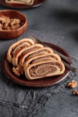 Ev yapımı cevizli dürüm, dilimlenmiş bejgli, ceviz dolgulu geleneksel Macar tatlı ekmeği. Doğu Avrupa Noel 'i ve cevizli Paskalya turtası. Masaya yakın çekim yap. Kopyalama alanı olan dikey üst görünüm