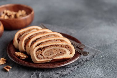 Ev yapımı cevizli dürüm, dilimlenmiş bejgli, ceviz dolgulu geleneksel Macar tatlı ekmeği. Doğu Avrupa Noel 'i ve cevizli Paskalya turtası. Masaya yakın çekim yap. Kopyalama alanı olan yatay kenar görünümü