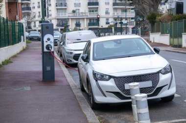 Elektrikli araba şarj istasyonunda şarj oluyor. Çevre bilinci yaşam tarzı konsepti için yenilenebilir temiz enerji arabası. Şehrin elektrik santrali EV aracı için çevre dostu sürdürülebilir tedarik sağlıyor