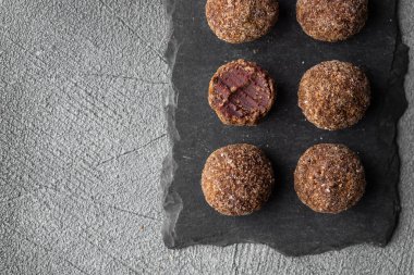 Koyu arkaplanda meyve ve böğürtlen, el yapımı veya el yapımı bonbonlar, çikolatalı veya şekerleme konsepti olan zanaatkar çikolatalı trüf şekerleri. Yatay pankart, boşluğu kopyala