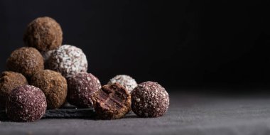 Gurme el yapımı vejetaryen çikolatalı trüf şekerlemelerden oluşan bir çeşitlilik. Isırılmış el yapımı bonbon çikolata konsepti. Kopyalama alanı olan yatay pankart