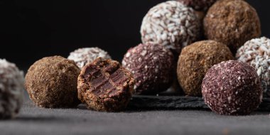 Gurme el yapımı vejetaryen çikolatalı trüf şekerlemelerden oluşan bir çeşitlilik. Isırılmış el yapımı bonbon çikolata konsepti. Kopyalama alanı olan yatay pankart