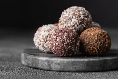 Premium şekerleme dükkanının koyu mermer arka planında el yapımı vejetaryen çikolatalı trüf şekerleri. El yapımı bonbonlar çikolata konsepti. Kopyalama alanı olan yatay pankart