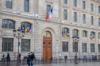 Paris, Fransa, 22 Şubat 202: Bir Fransız bayrağı, Paris 'in ulusal gururunu, şehrin zarif mimarisini ve zamansız cazibesini simgeleyen klasik bir Paris binasında gururla dalgalanıyor